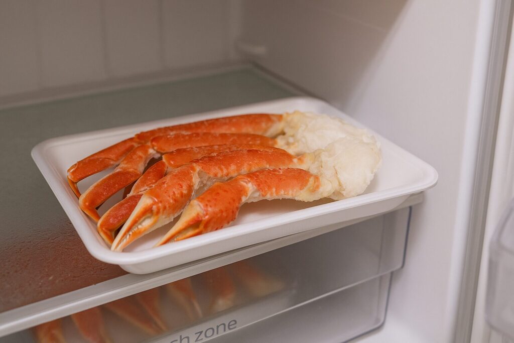 冷蔵庫にカニ脚が入っている、トレーに載せた半解凍の状態。