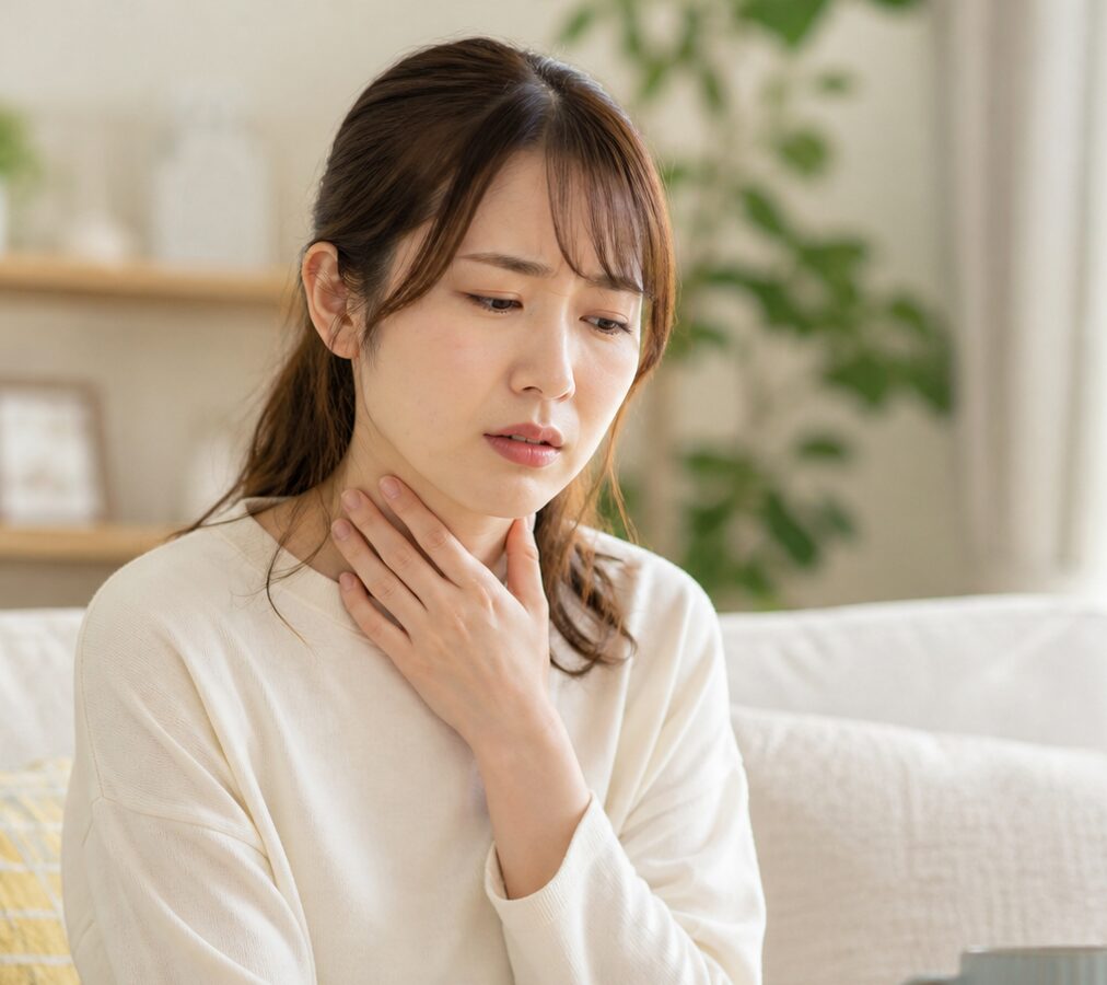 のどヌールスプレーを使うか悩んでいるのどの痛みがある女性の様子